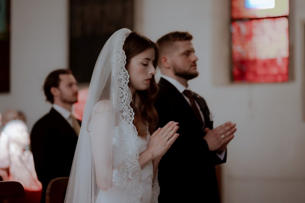 para młoda podczas modlitwy w czasie ceremonii ślubnej