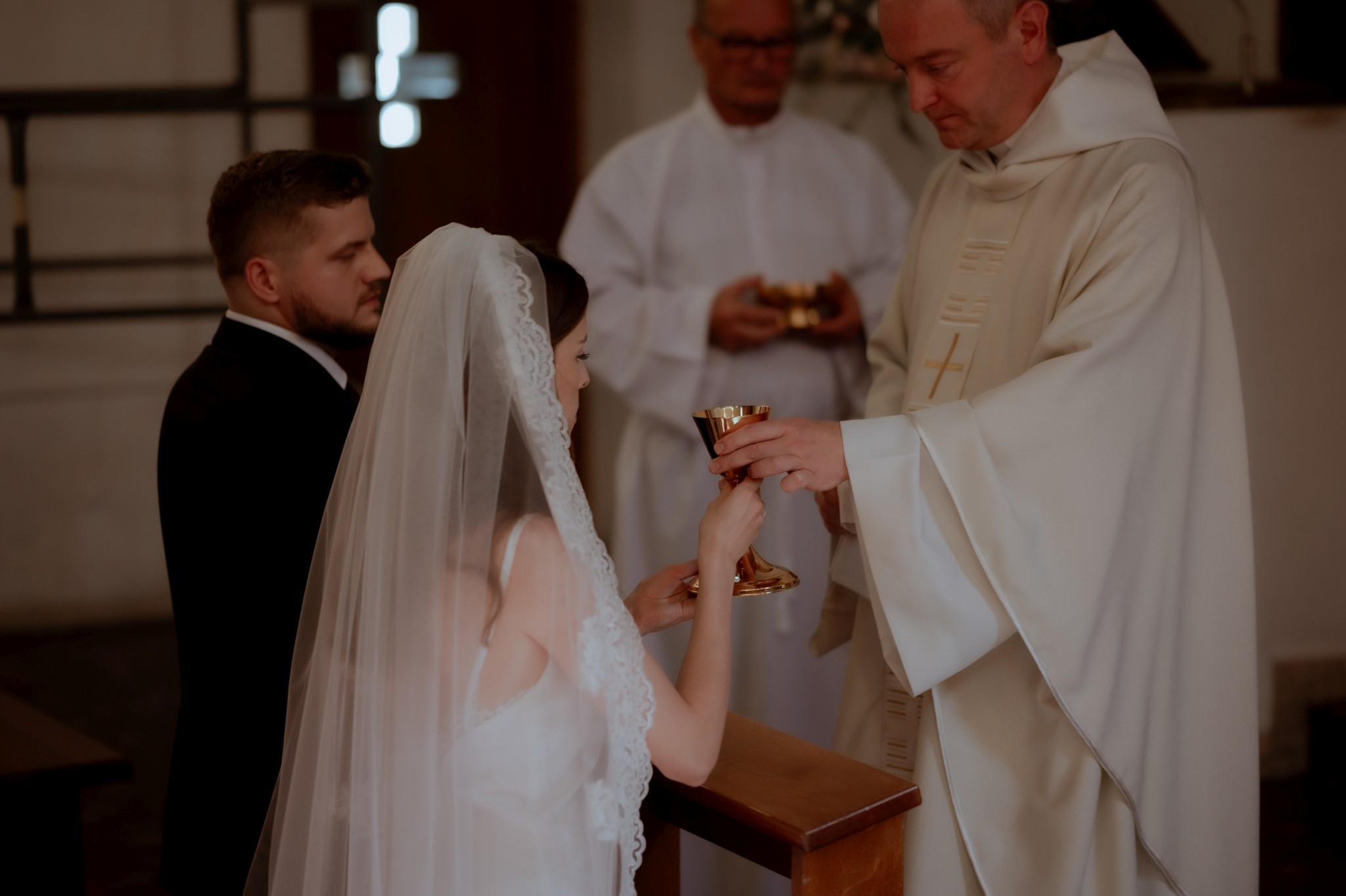 ksiądz podaje kielich pannie młodej podczas Komunii Świętej