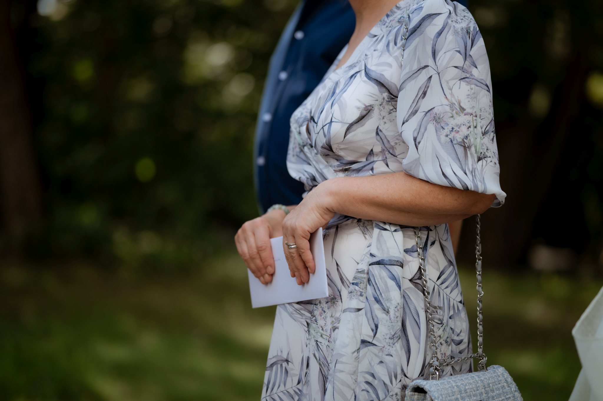 pani trzyma kopertę z pieniędzmi podczas życzeń ślubnych