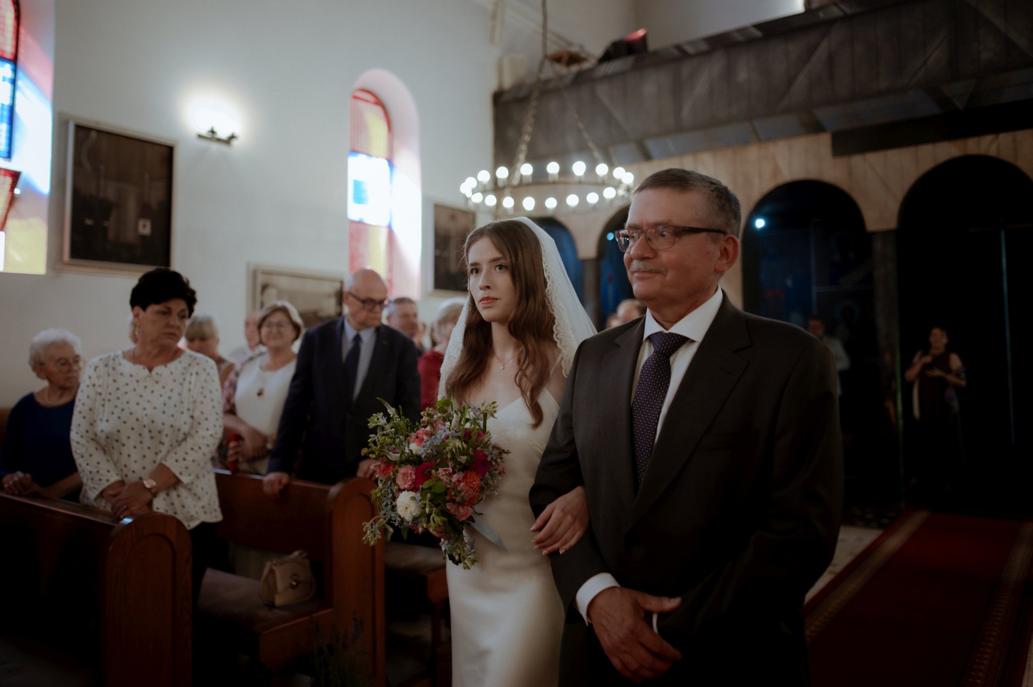 wzruszony tata prowadzi pannę młodą do ślubu