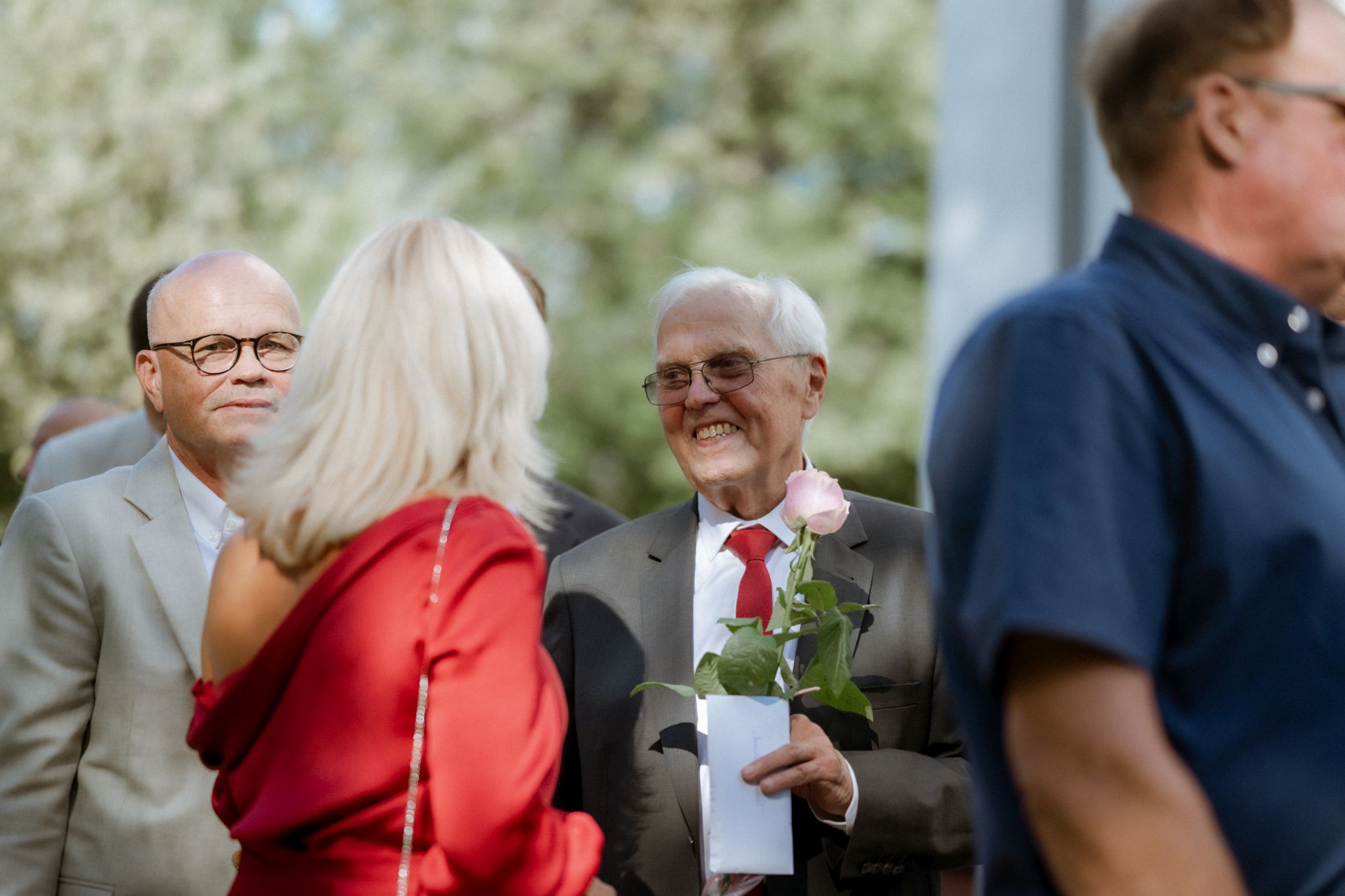 goście wręczają kwiaty parze młodej pod kościołem