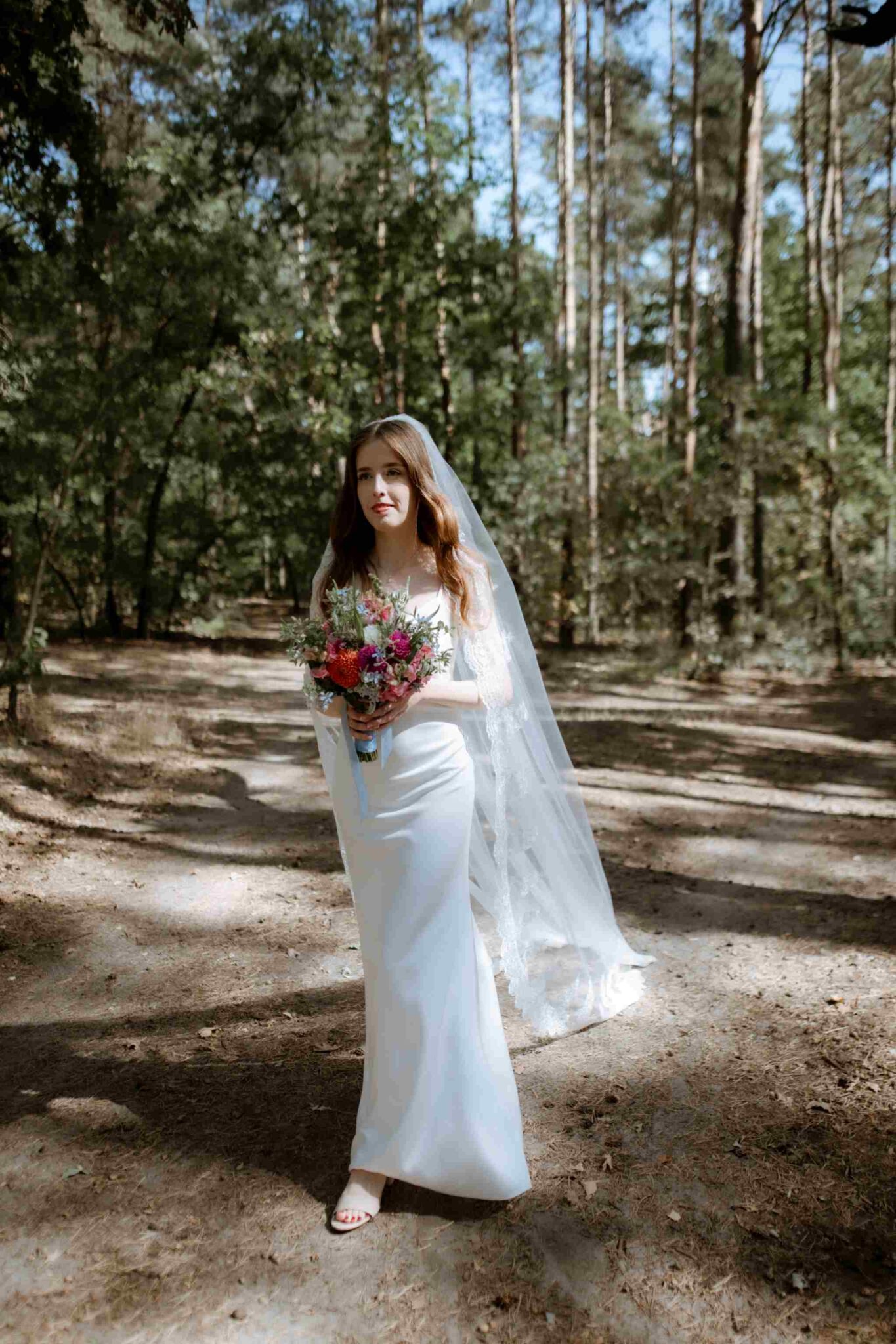 panna młoda idąca przez las na first look
