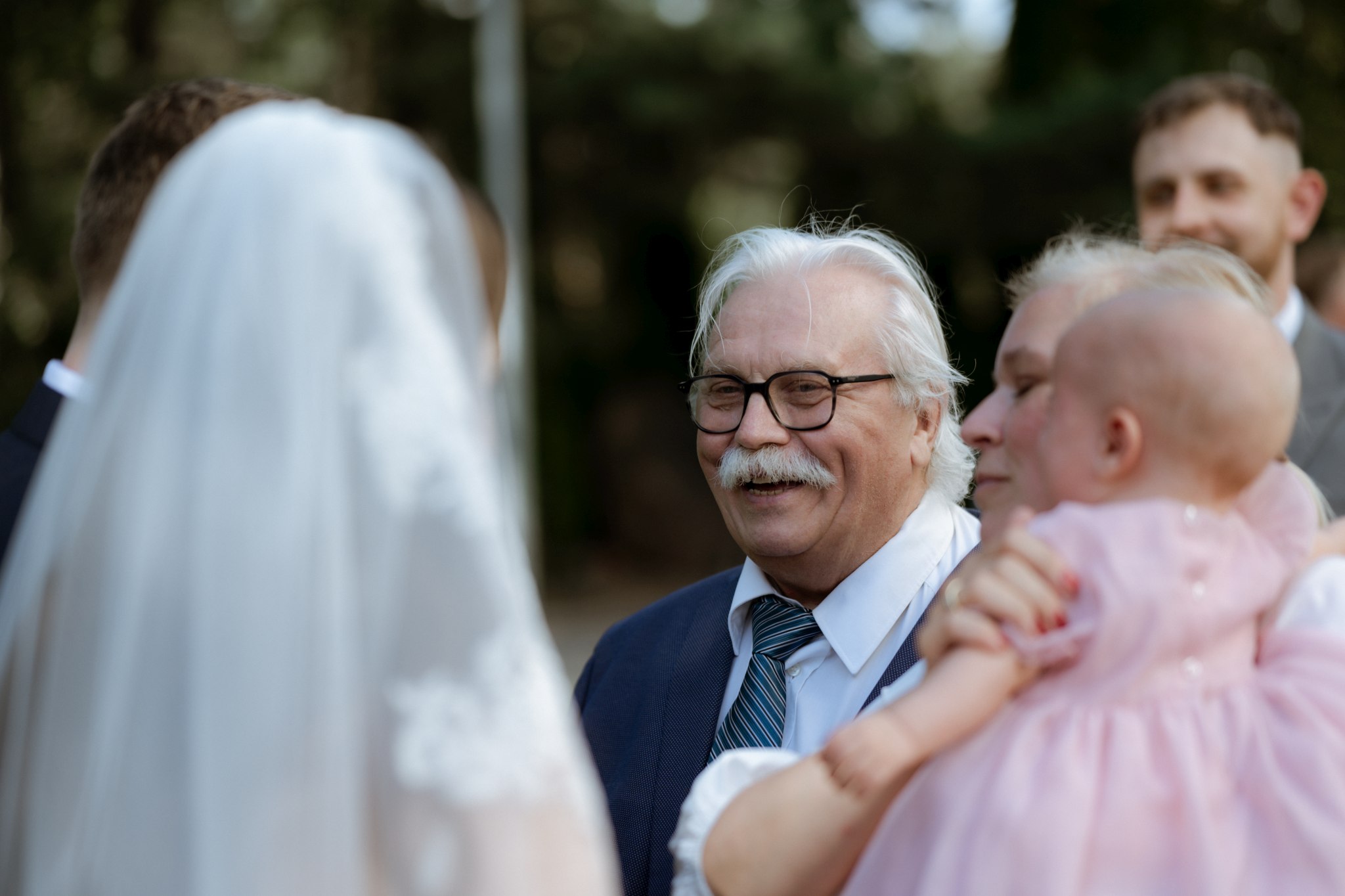rodzina i przyjaciele składają życzenia po ceremonii ślubnej